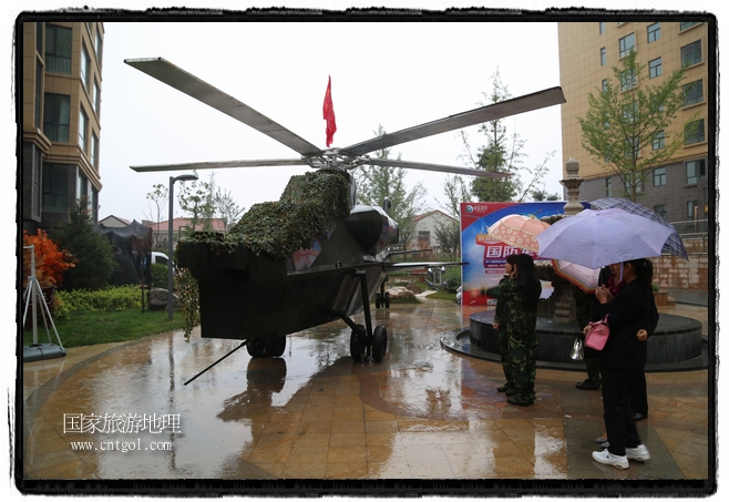 小區(qū)突然出現(xiàn)“飛機(jī)坦克”，其中殲15艦載戰(zhàn)斗機(jī)一架、99式主戰(zhàn)坦克一輛、武直-10武裝直升機(jī)一架，吸引了眾多市民雨中圍觀、合影。